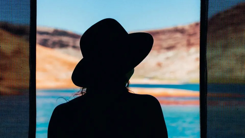 Profili falsi: una donna con il cappello in controluce davanti a una finestra