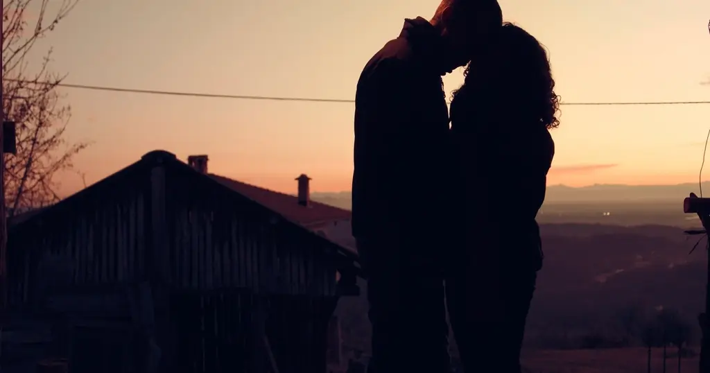 Incontri sesso: una coppia si bacia in controluce al tramonto